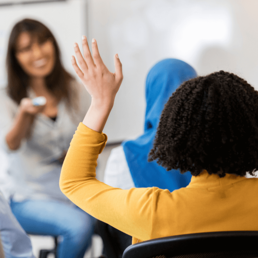 student raising hand with smiling teacher